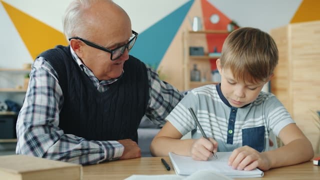An adult mentor helping a student with homework at a desk